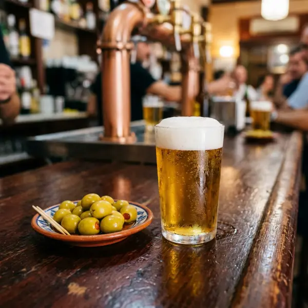 Caña de cerveza bien fría con aceitunas